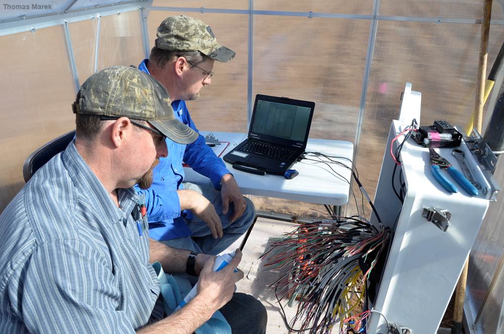 Drs. Gary Marek (back) and Kevin Heflin wire an array of 84 soil sensors into a programmable data logger and test for  connectivity on a winter day in 2018. 